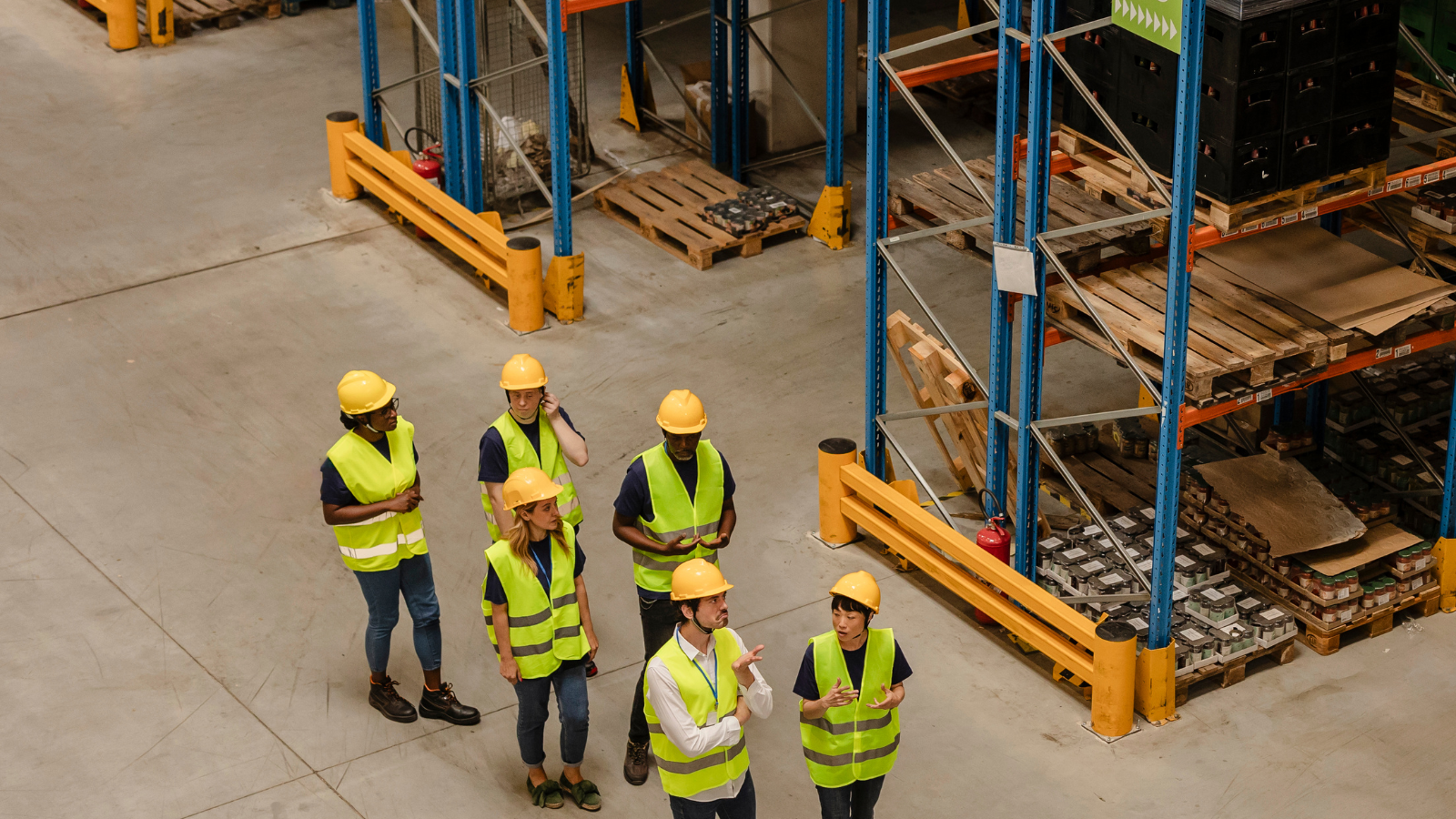 Employee wearing gloves and helmet as part of a warehouse safety checklist for small businesses.