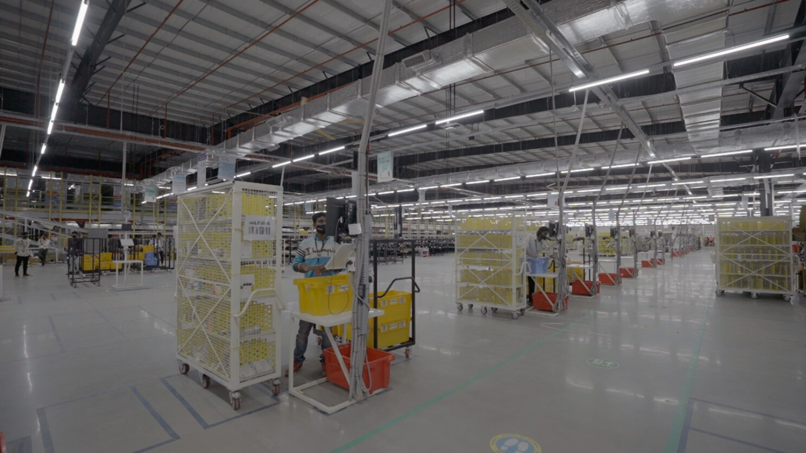 Inside a hyperlocal dark store warehouse in India with workers picking and packing orders for rapid quick commerce delivery.