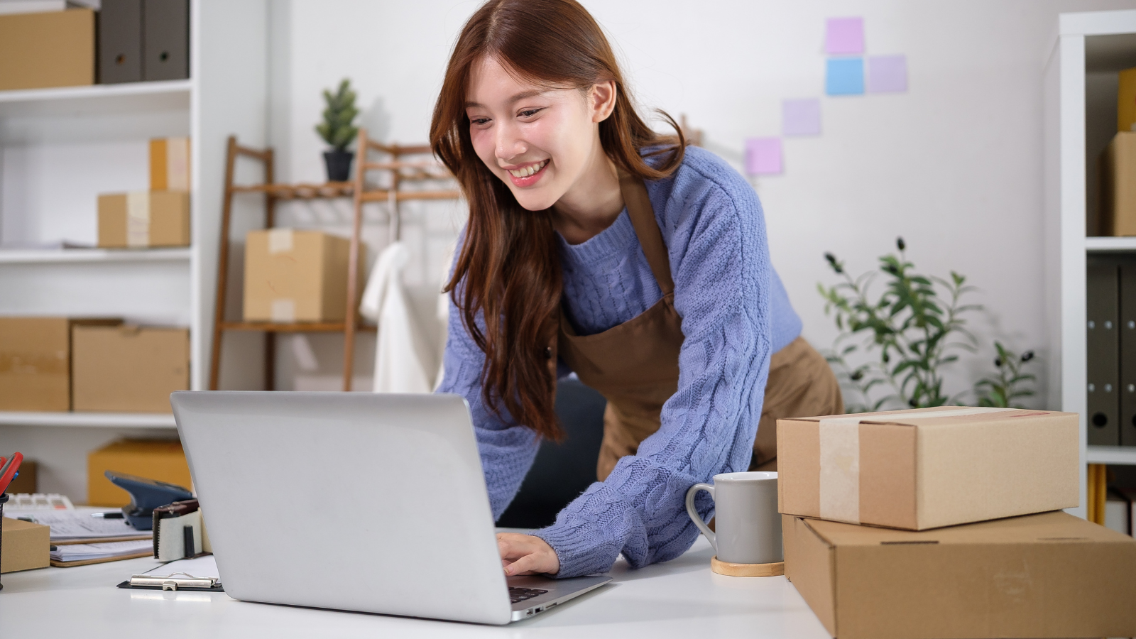 d2c brand managing quick commerce operations with laptop and packaging in fulfillment setup