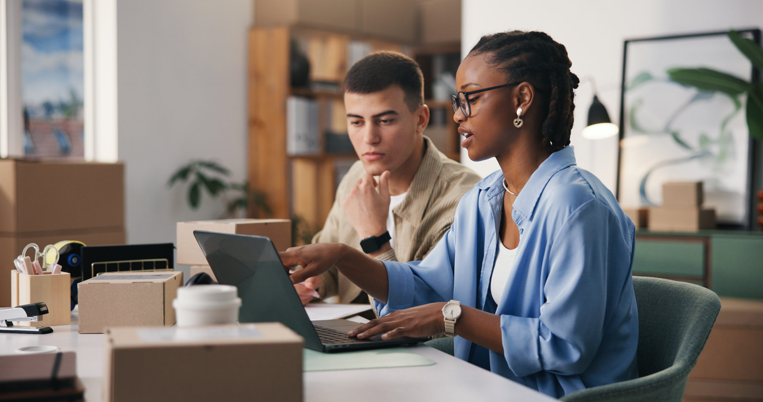 Ecommerce operations team reviewing orders on a computer, one team member wearing a headset