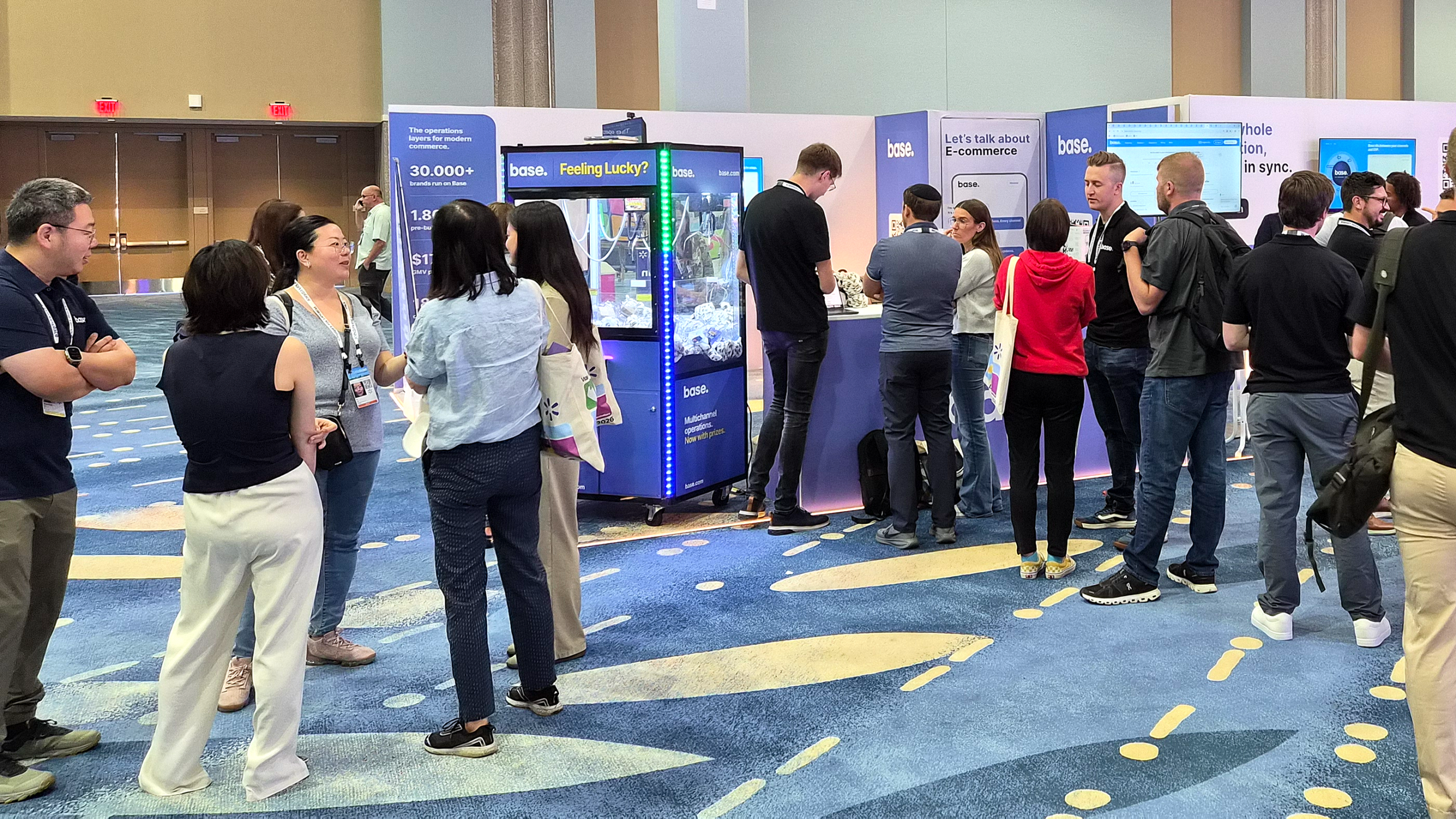 Sellers gathered around the Base claw machine at booth 1602 during Walmart Let's Grow 2026