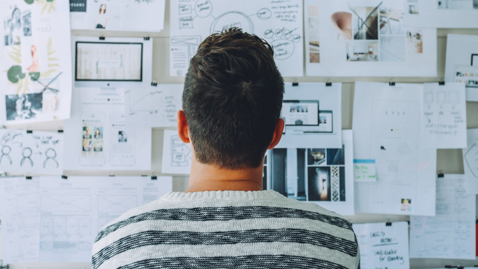Person analyzing strategy boards and visual data while planning a digital commerce or business growth strategy.