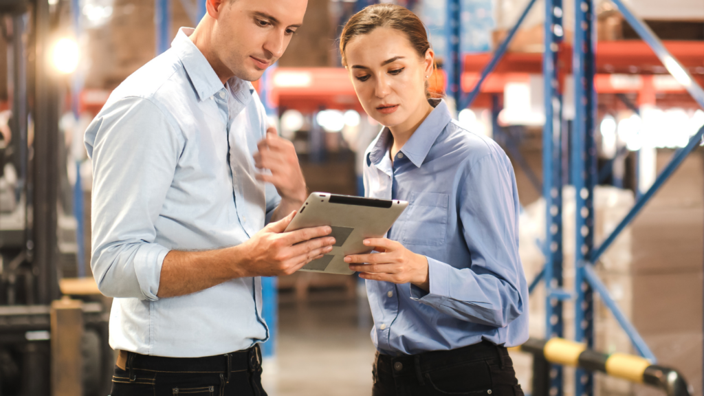 Warehouse professionals reviewing inventory and fulfilment operations on a tablet