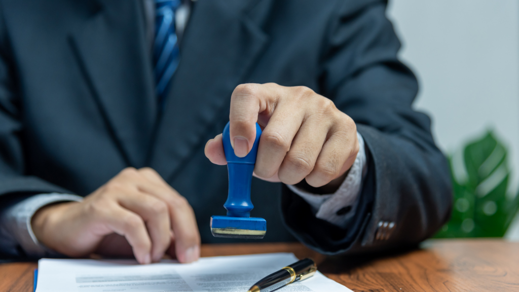 Business professional reviewing documents while completing a formal approval process