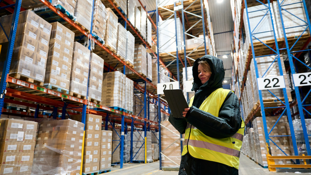 Warehouse worker using a handheld device to manage inventory and warehouse operations in a storage facility