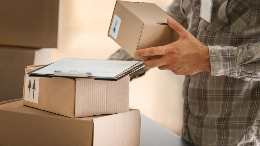 Ecommerce packing process showing a worker selecting and handling cartons for accurate and efficient product packaging
