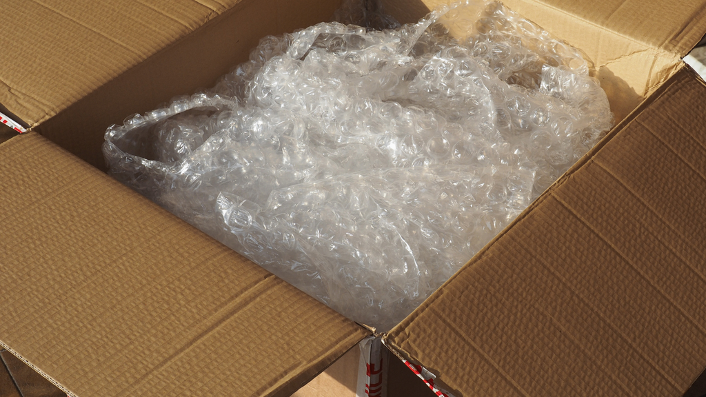 Bubble wrap and excess void fill inside a shipping carton illustrating how packaging material can increase parcel dimensions
