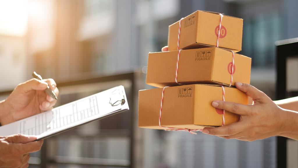 Ecommerce worker handling packaged orders and checking shipment information before dispatch