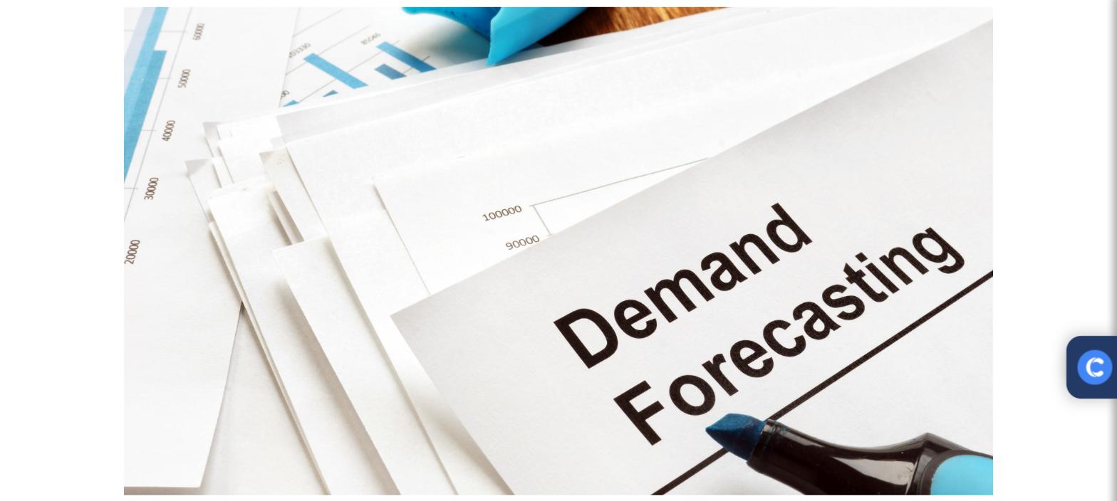 Stack of demand forecasting reports with bar charts and a marker pen
