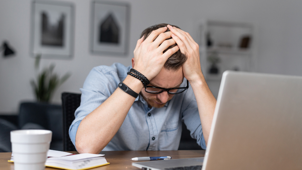 Stressed operations professional reviewing warehouse workload and peak-sale challenges