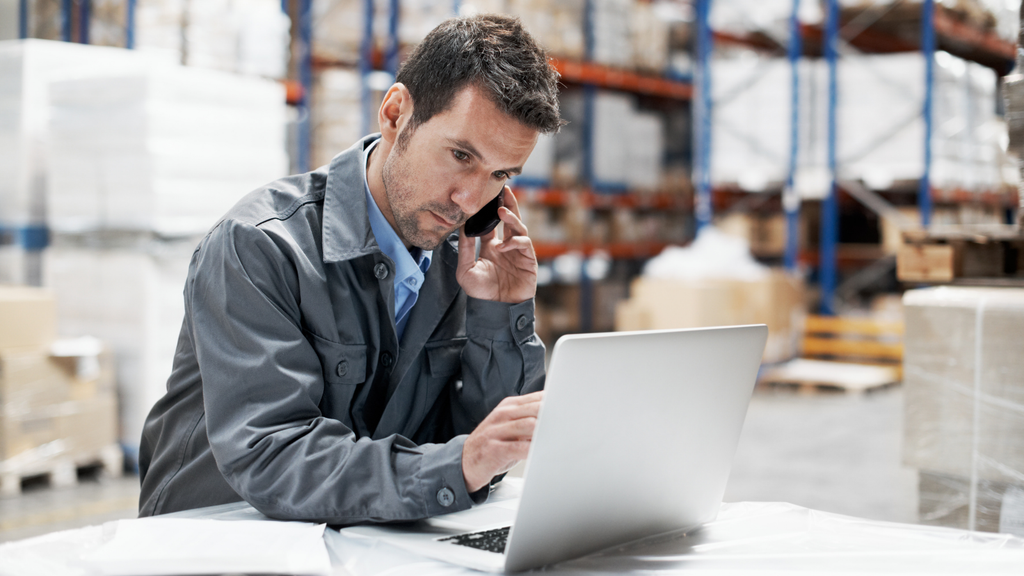 Warehouse worker using a laptop to manage ecommerce orders and fulfillment operations