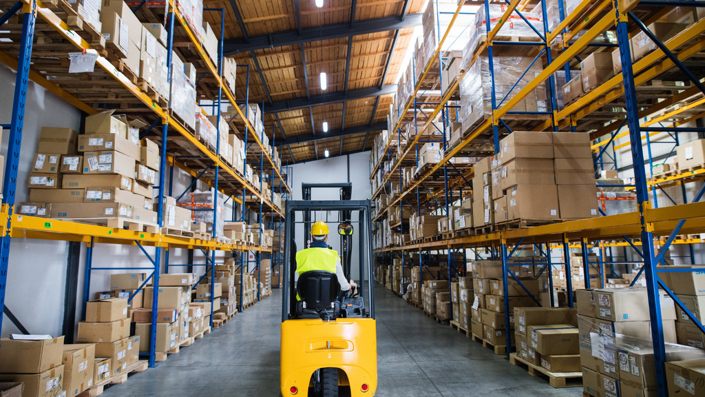 Warehouse aisle with storage racks and inventory, illustrating multi-warehouse order routing and stock allocation.