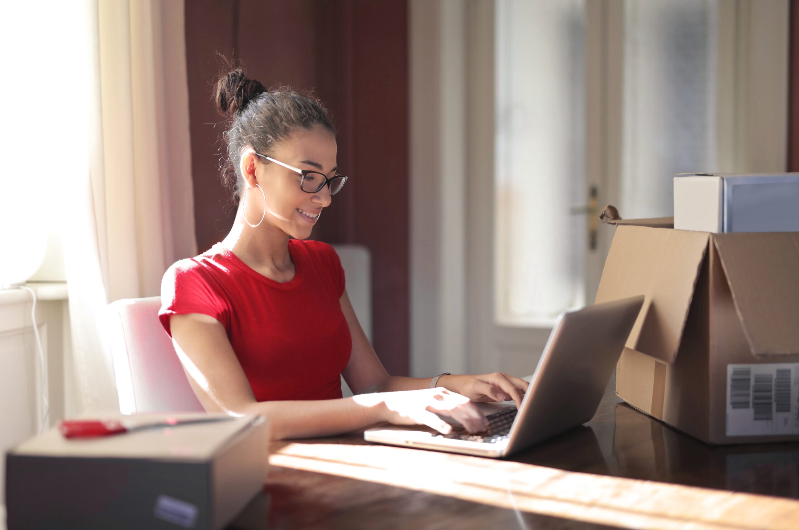 Una mujer mirando su computadora, sonriendo, pensando en cómo funciona Easy en Argentina.