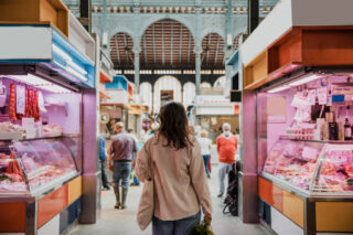 Mujer observando dos tiendas en el mercado