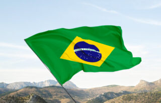 Bandera brasileña izada frente a un paisaje montañoso